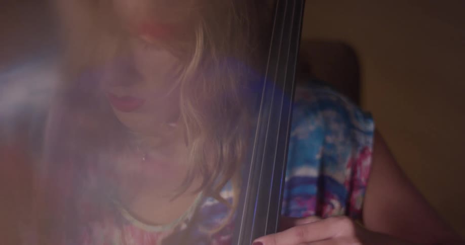 A woman sits and plays the cello