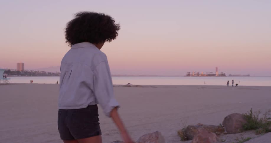 A woman roller skates near the beach