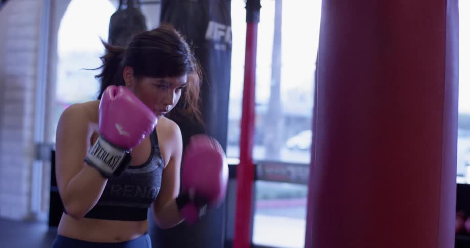 A woman is punching the heavy bag