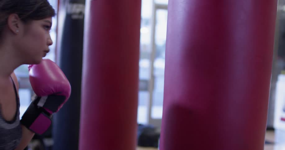 A woman is punching the heavy bag