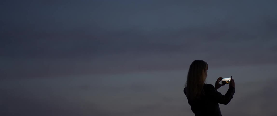 A woman is photographing at dawn