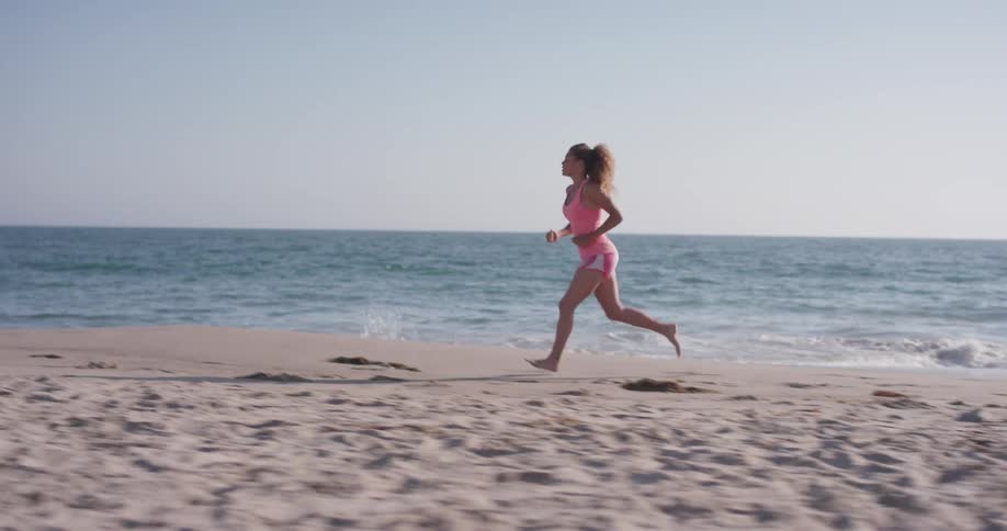Woman jogs on the beach on a sunny day