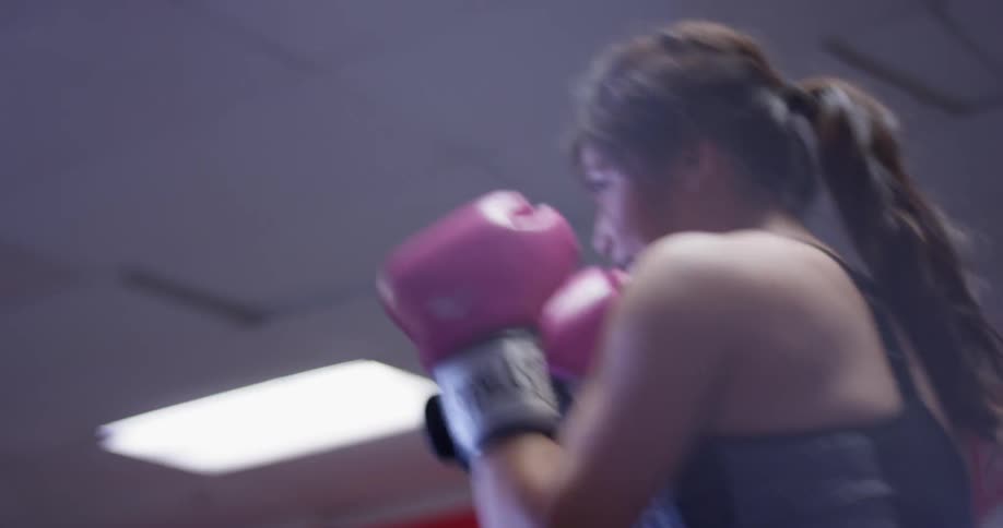 A man and woman train inside a boxing gym