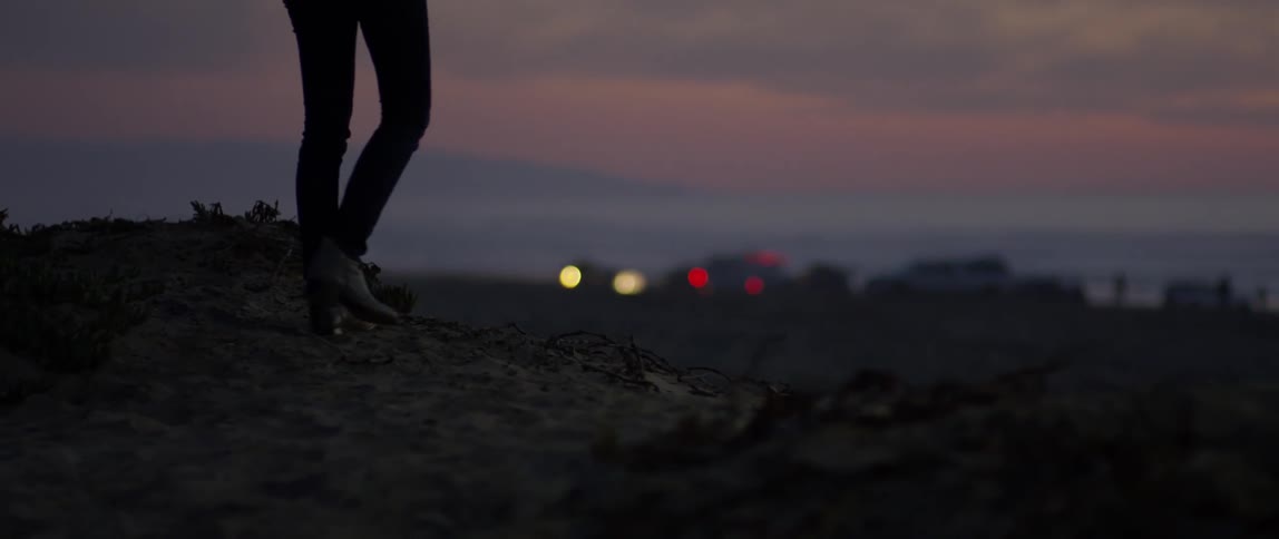 A woman walks outside at sunset