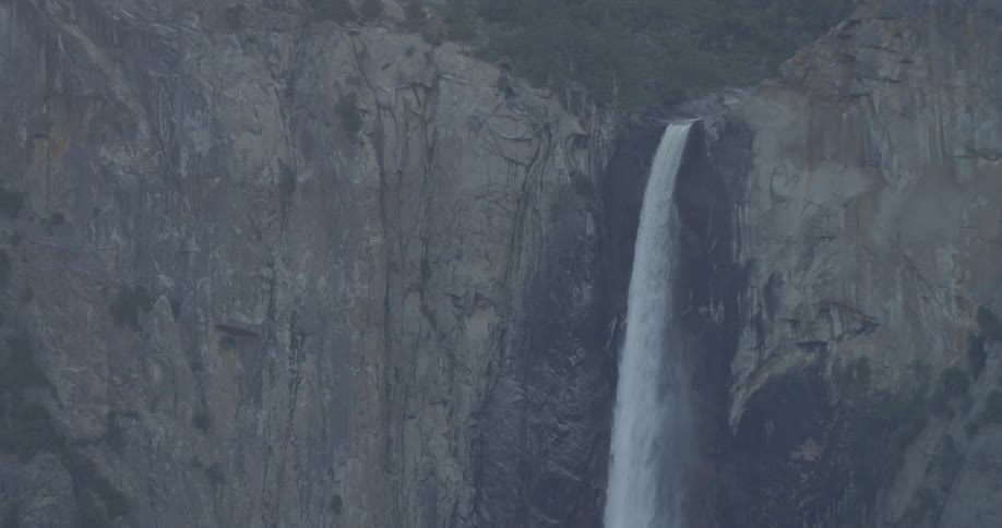 A waterfall flows over a cliff in the wilderness