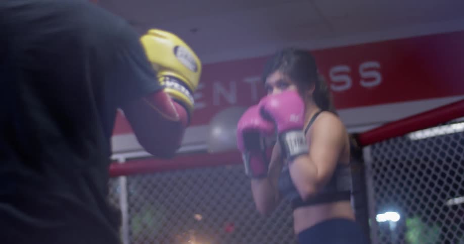 A man and woman train inside a mma ring