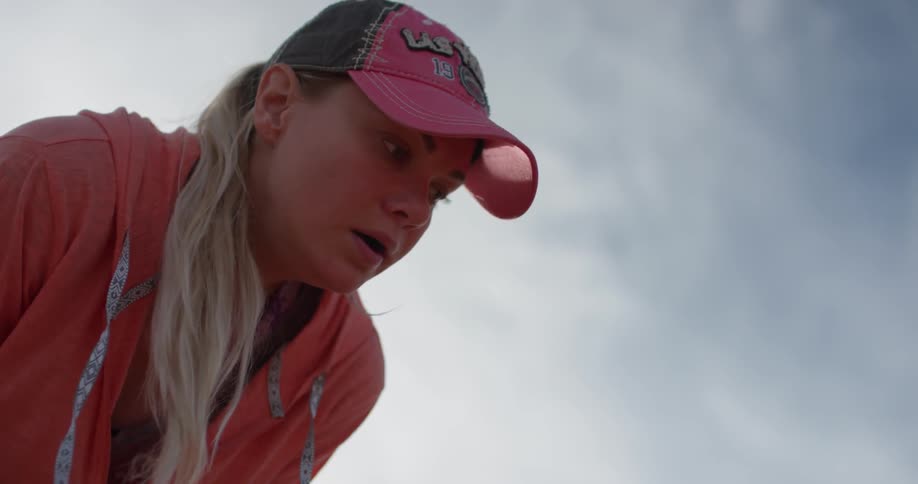 A woman leans forward on a cloudy day