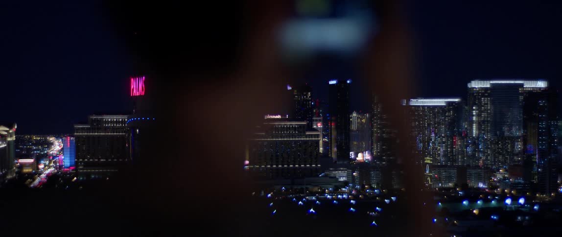 A woman takes a picture of las vegas at night