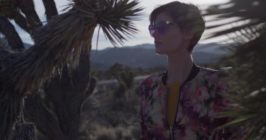 A woman wearing sunglasses is in the desert