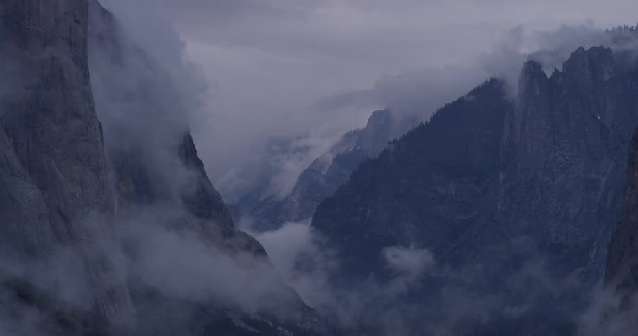 Clouds float above tall mountains