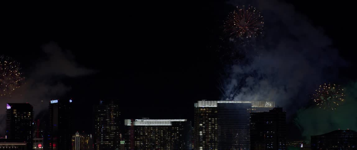 Fireworks in the night sky above city buildings