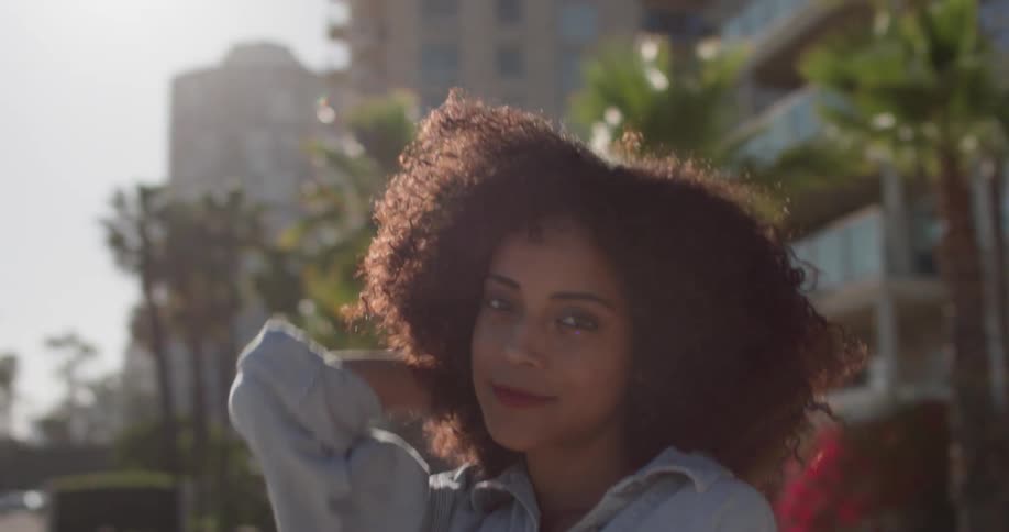 A woman smiles and walks outside under the sun