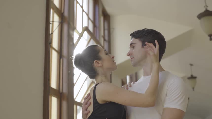A male and female ballet dancer rehearse in a studio