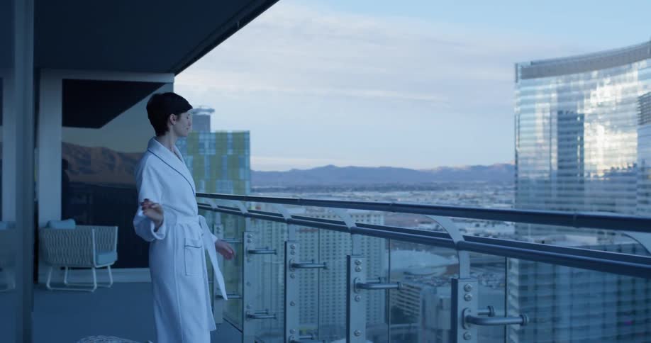 A woman wears a robe on a hotel balcony in las vegas