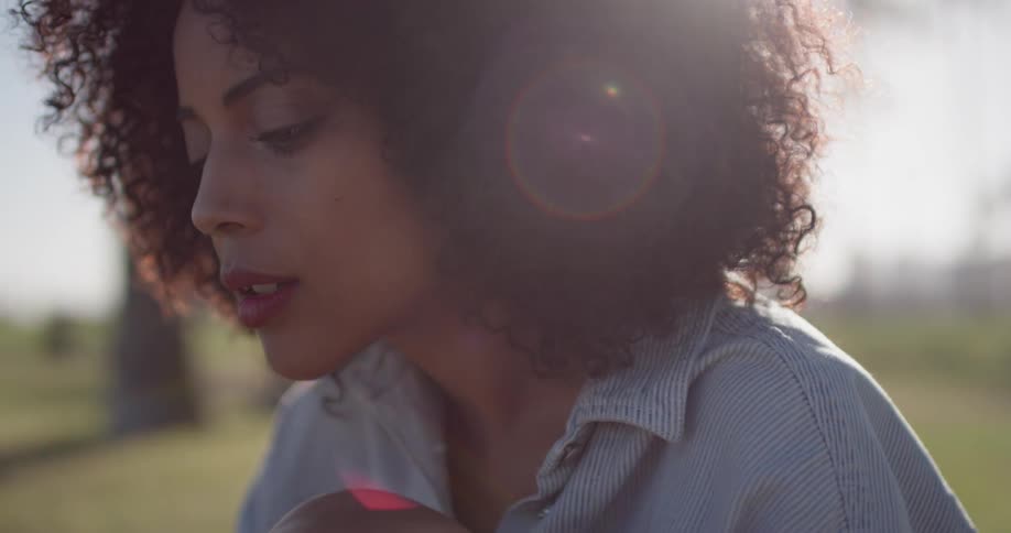A woman leans forward sitting on a sunny day