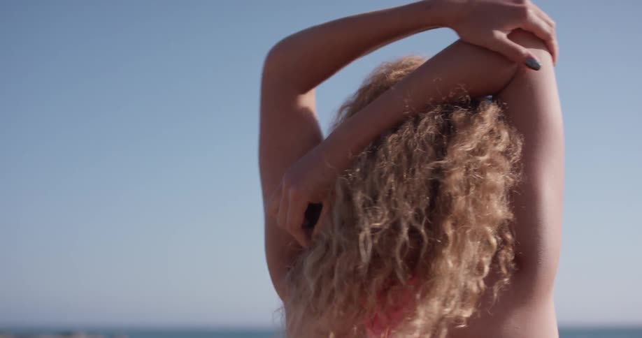 Woman stretches her arms outside on a sunny day