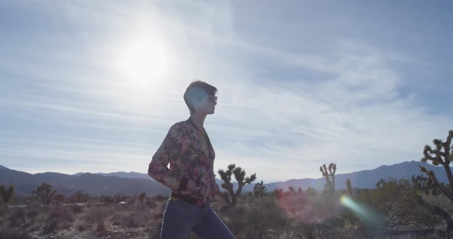 A woman walks alone in a desert