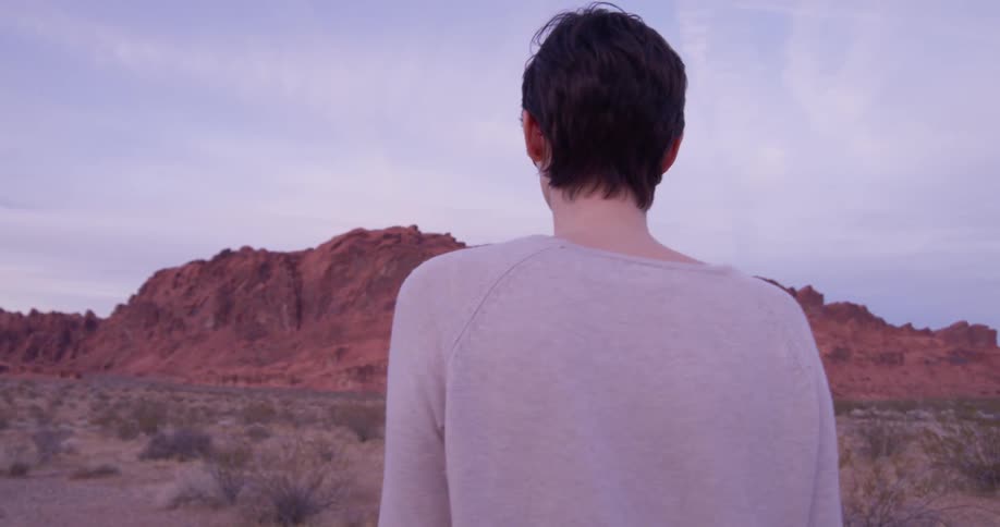 Woman walks outside in the desert in the evening
