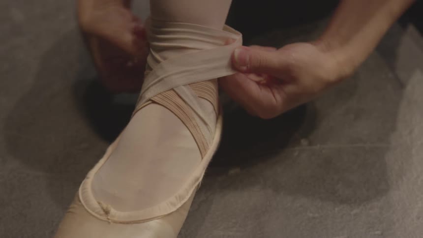 A woman adjusts the straps on her shoes