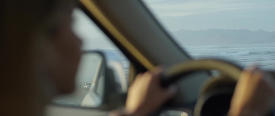 Woman steers a car on a sunny day