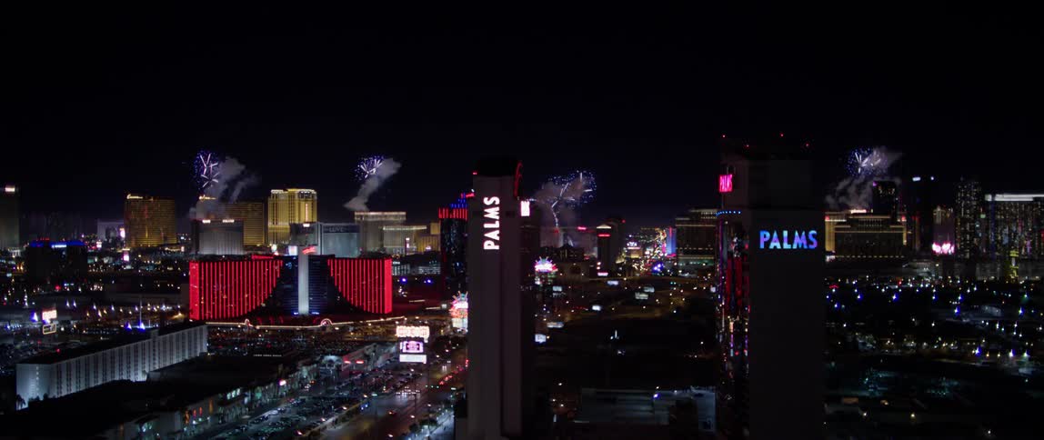 Fireworks explode in the night sky over a city
