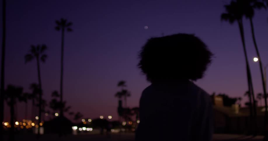 Woman sways outside in the city at night