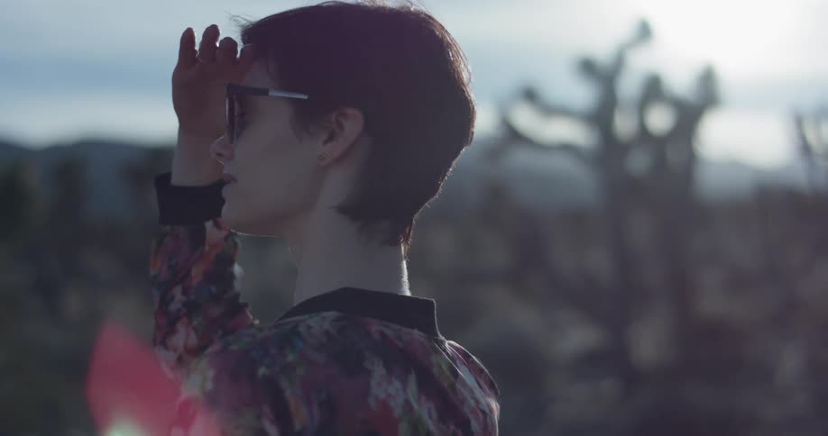 Woman wearing sunglasses shields her eyes from the sun