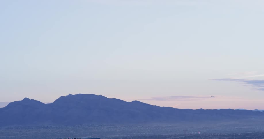 An airplane flies in the sky at sunset