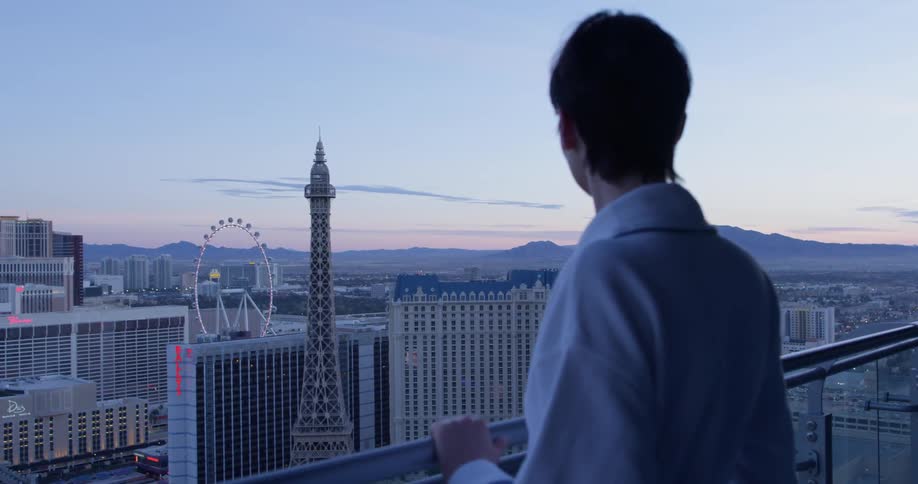 A woman takes in the view of the city from her balcony