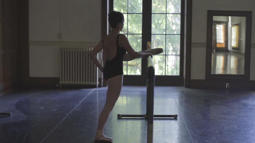 A ballerina practices in the gym