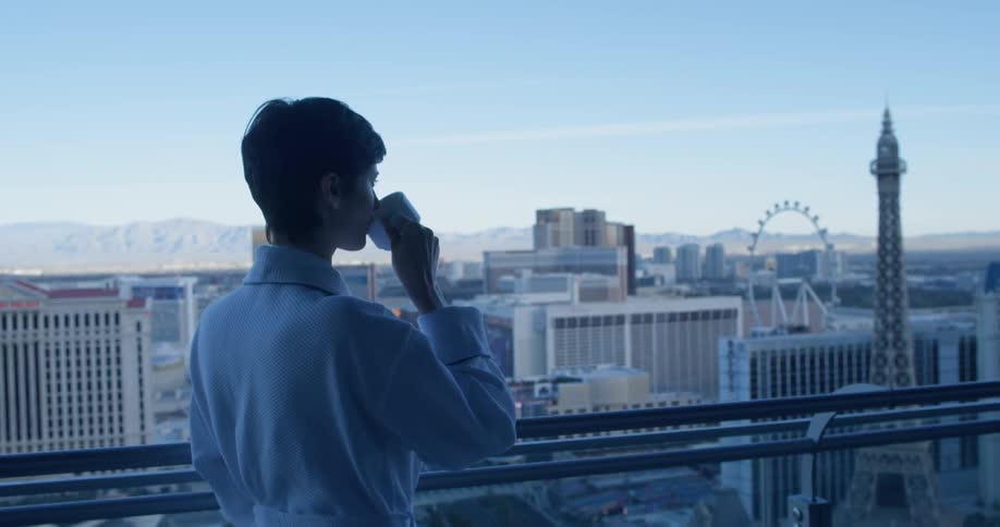 A woman drinks coffee on a hotel balcony in las vegas