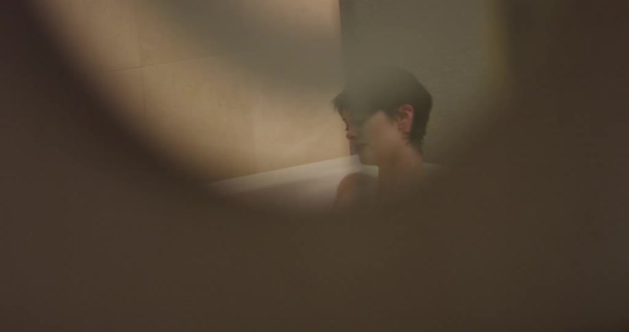 Woman bathes herself in a large tub