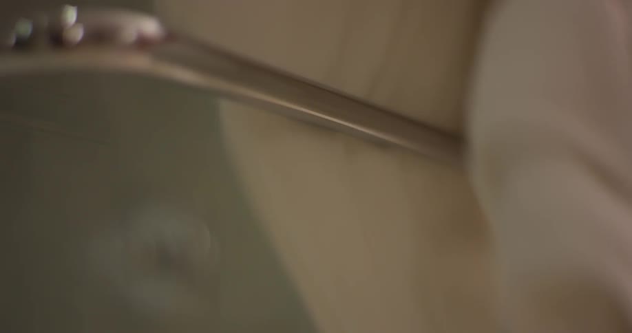 A woman removes a towel from a towel rack