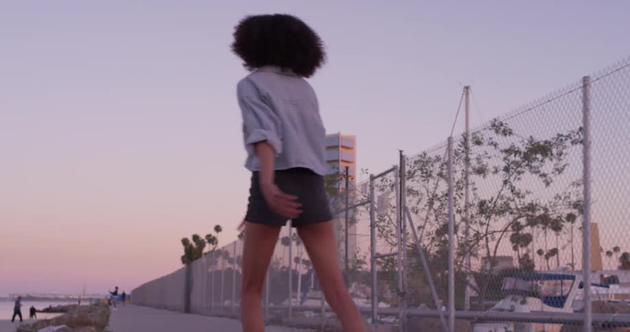 The woman is rollerblading near the shore