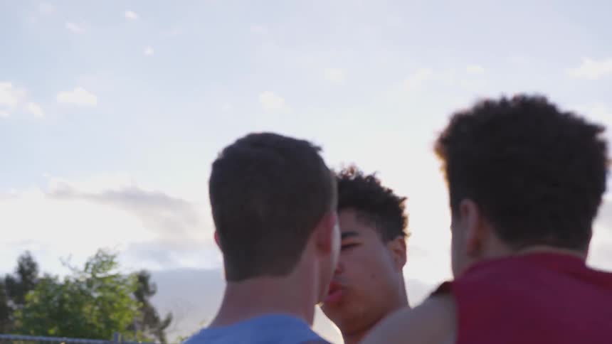Two athletes get into an argument on an outdoor athletic field at sunset