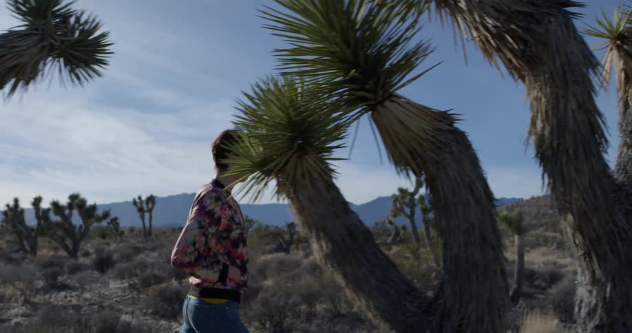 The desert is full of hills and a woman walking through