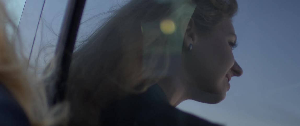 A woman is reflected in a car window