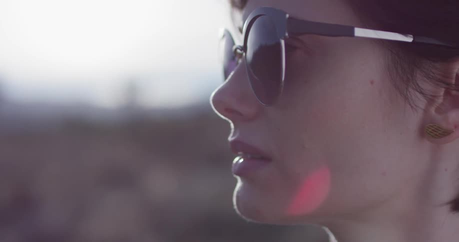 The woman looks forward in the desert with sunglasses