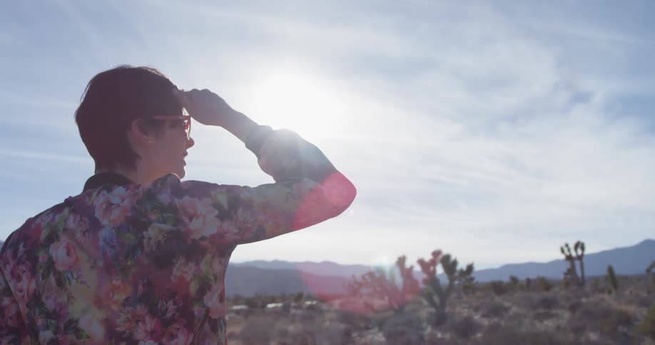 A woman stands alone in a desert
