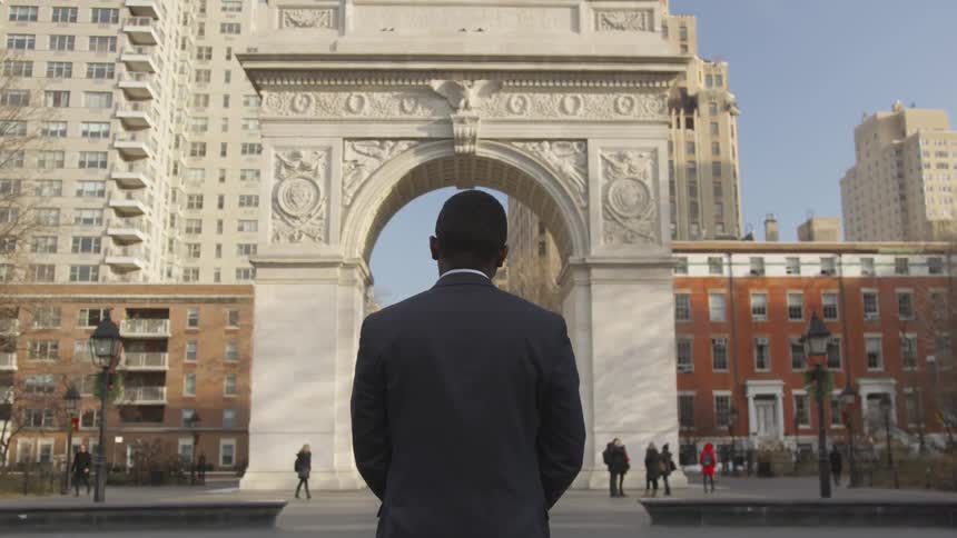 The man looks at the monument in the city