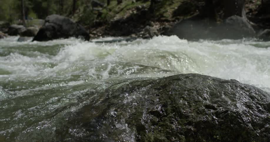 The water pours over the rocks in the stream