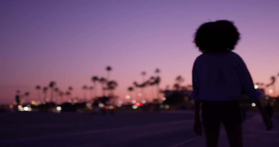 A woman skates on a boardwalk at dusk