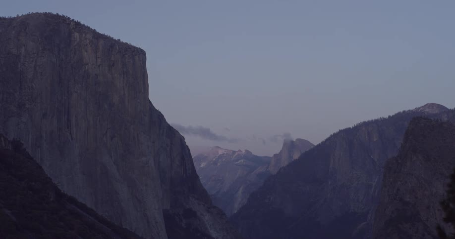 The clouds move past the tall mountains