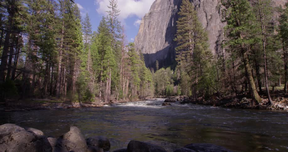 The sun is shining over the stream by the mountain