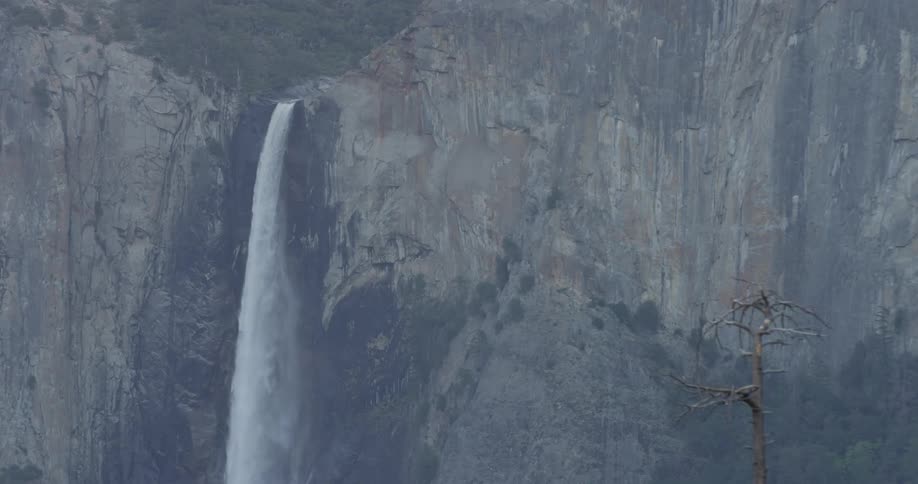A waterfall flows over a cliff in the wilderness