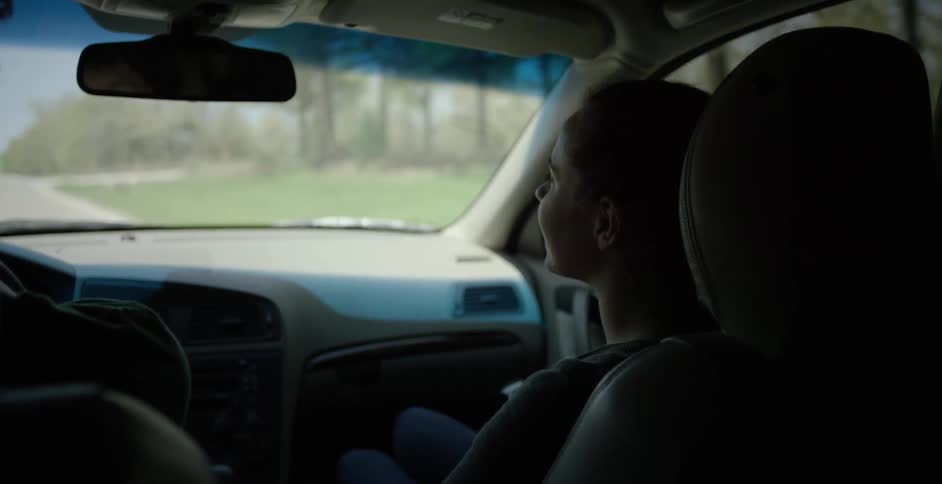 A woman sitting in a car talking on a ride