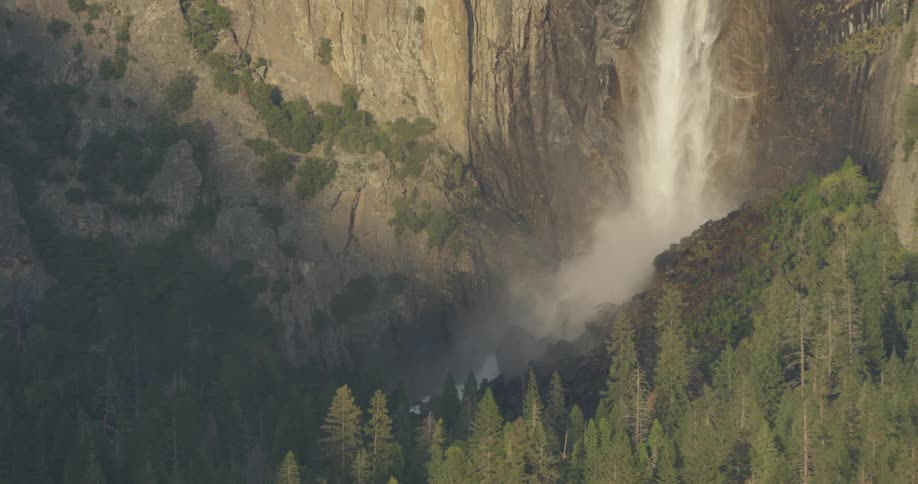 A waterfall flows over a cliff in the wilderness