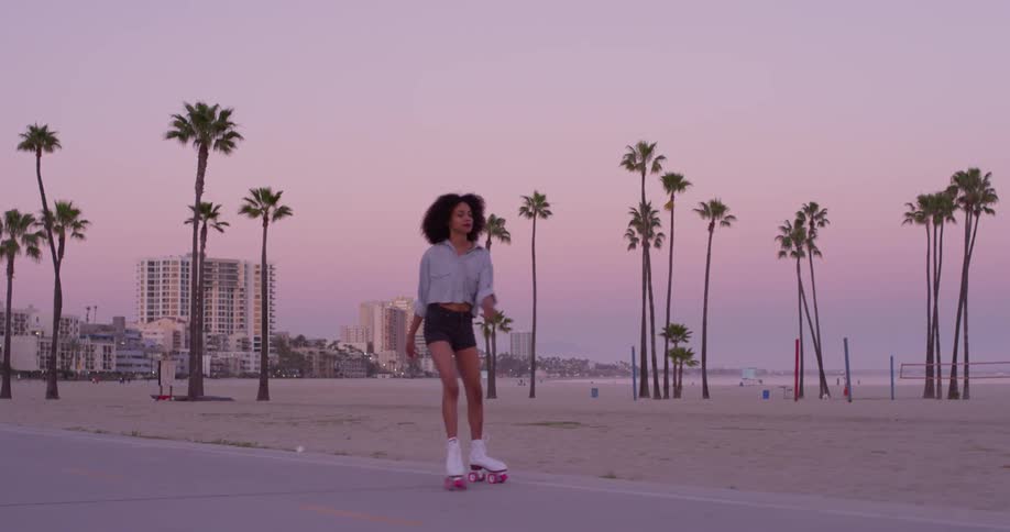 A woman roller skates near the beach