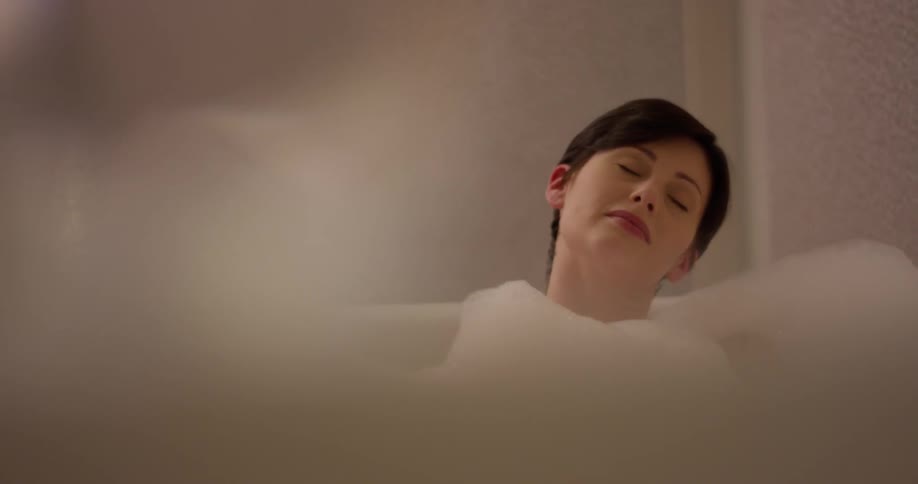 A woman relaxes in a bubble bath