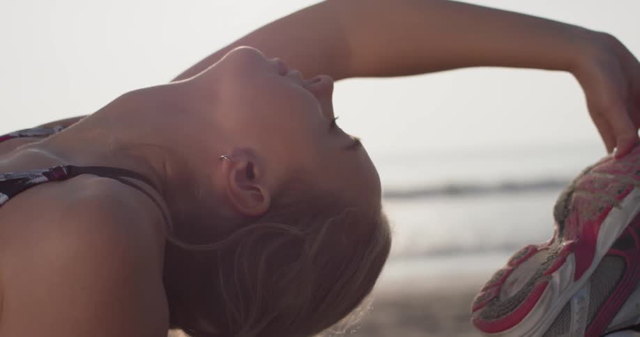A woman does yoga on a beach